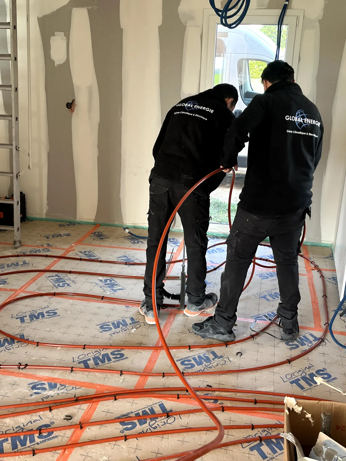 Techniciens à l’œuvre sur un plancher chauffant